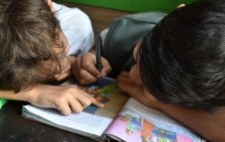 Niño escribiendo en su cuaderno en su primer año de primaria