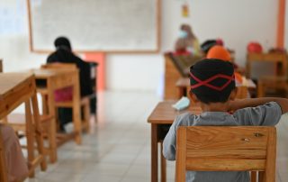 Niño sentado en su pupitre en un salón de primaria
