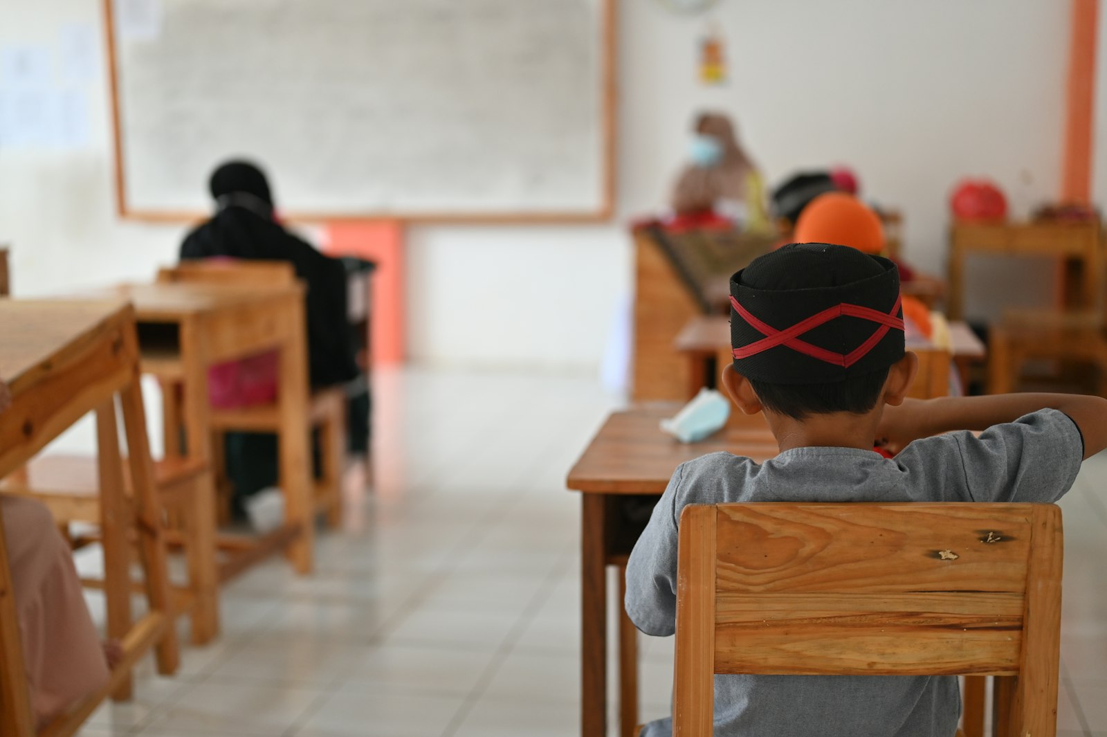 Niño sentado en su pupitre en un salón de primaria